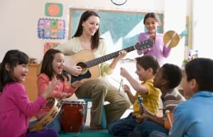 Teacher playing the guitar, kids playing different kind of instruments. 