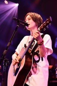 Young woman singing and playing the guitar