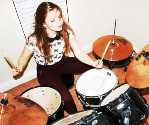 Teenager enjoying playing drums