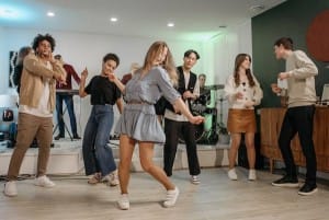 Teenagers joyfully dancing, and playing musical instruments in a band